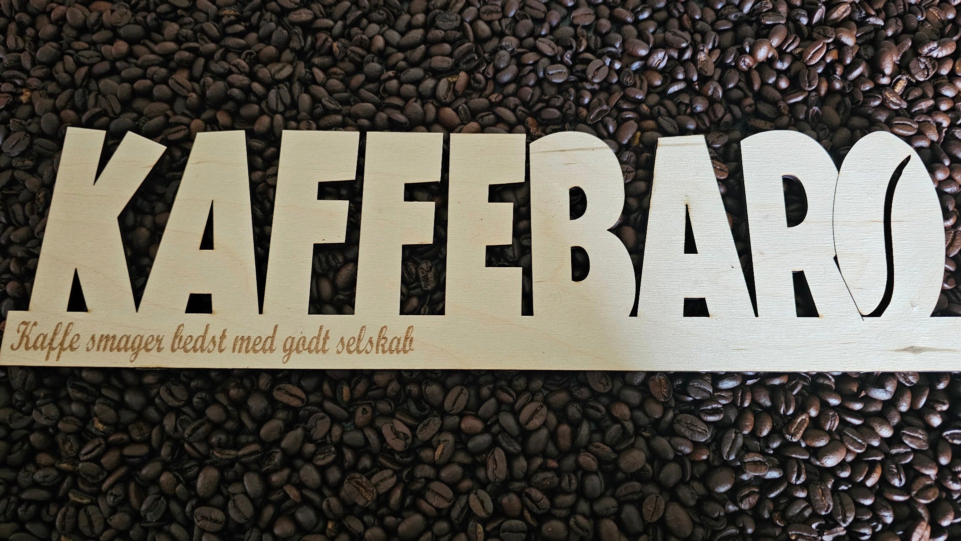 Kaffebar skilt i træ med teksten “kaffe smager bedst med godt selskab